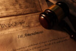 First Amendment and US Constitution text with legal gavel