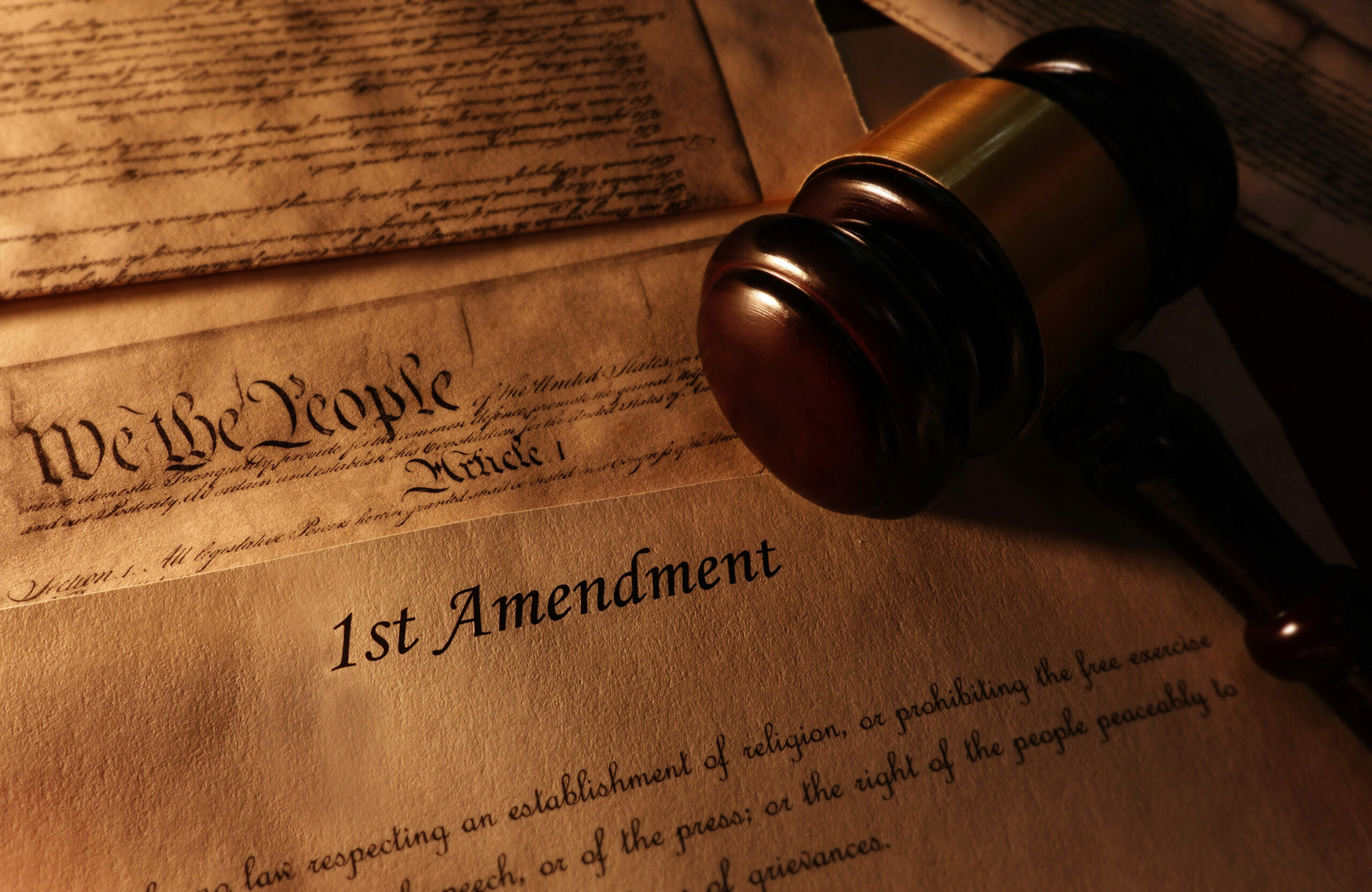 First Amendment and US Constitution text with legal gavel