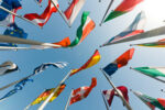 Stock photo of an assortment of countries' flags blowing in the wind on a sunny day
