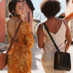Two models walking down a sunny street wearing wearwell purses