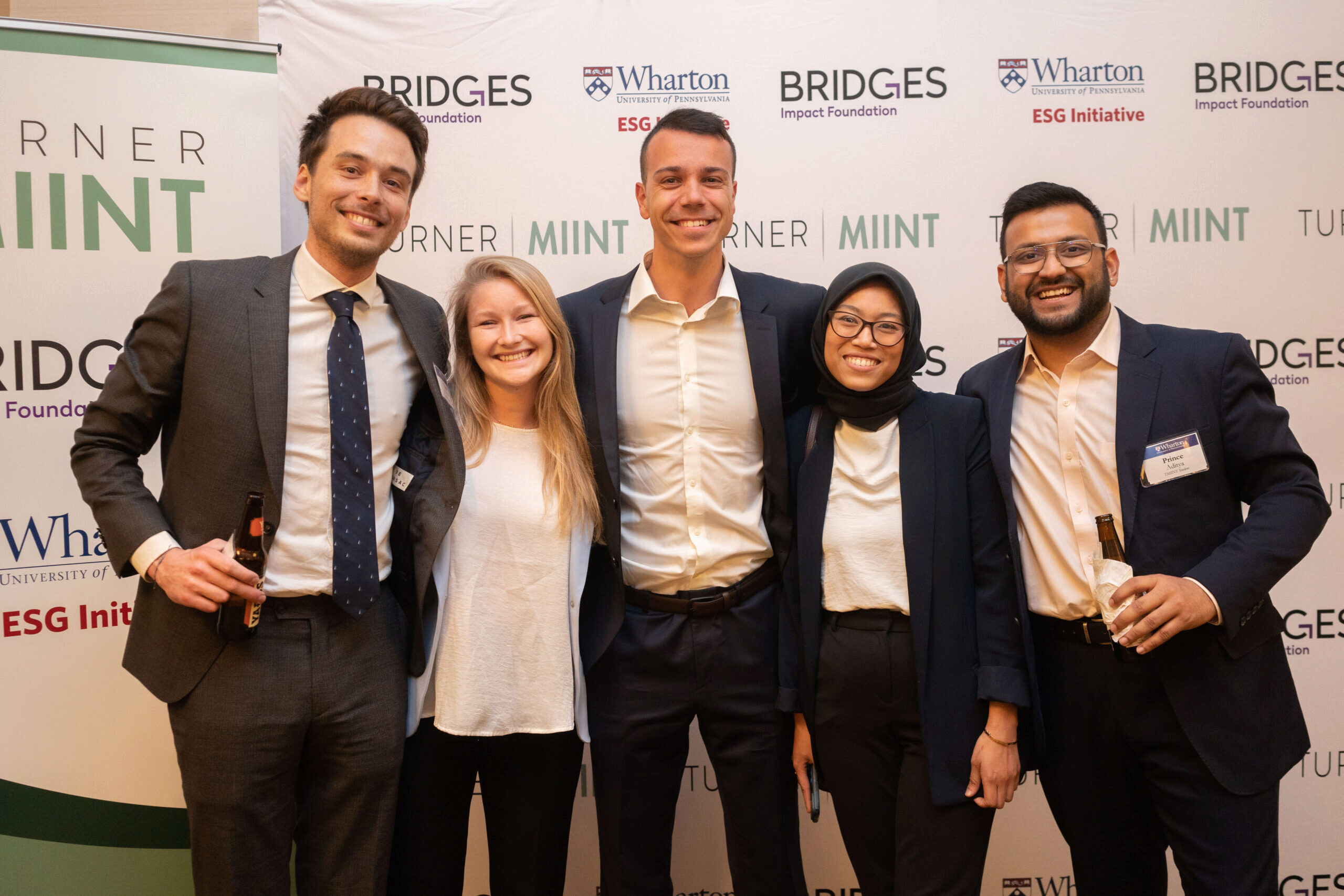TMIINT finalists posing in front of a banner that says Wharton ESG Initiatives, Bridges Impact Foundation, and Turner MIINT.