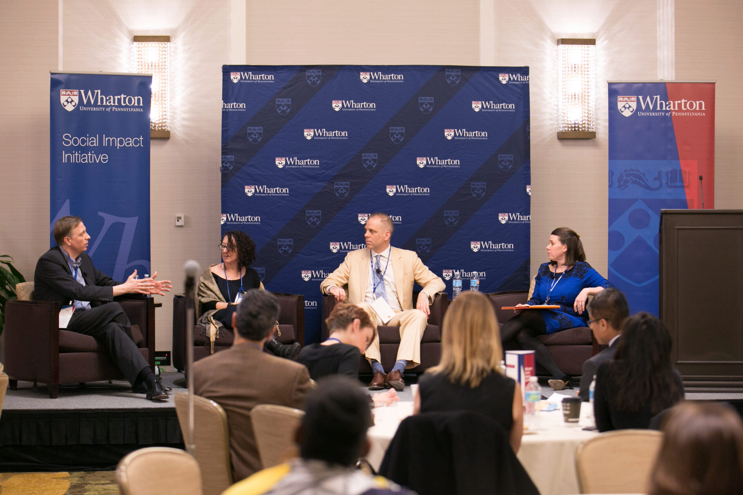 Image from 2017 Social Impact Initiative event with Suzanne Biegel, Sandra M. Hunt, and others on stage speaking before a room of professionals.
