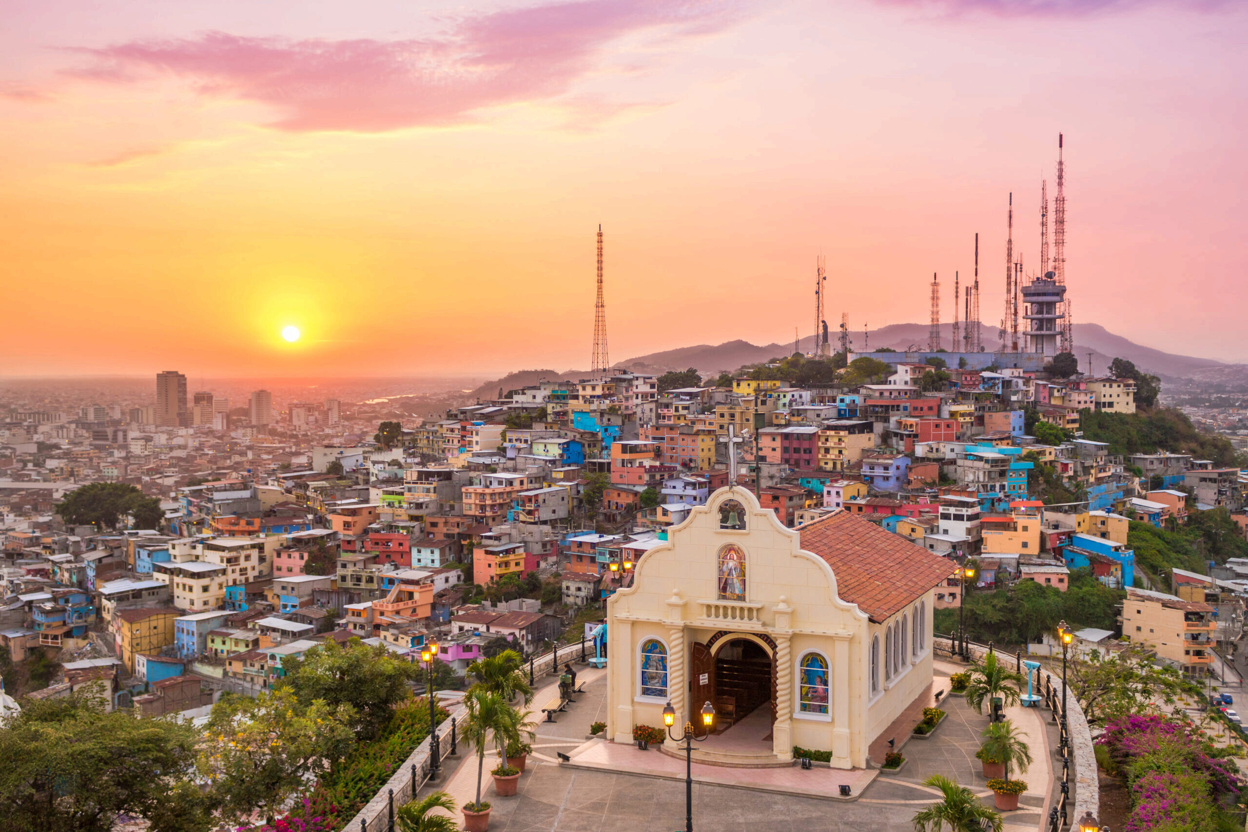 Decorative image of Sunset In The City Of Guayaquil with an old church in the foreground and colorful homes on a hill in the background