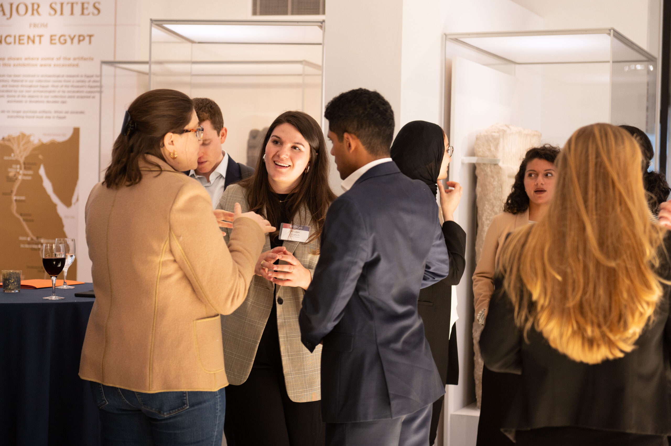 Close up photo of students enjoying a cocktail hour reception in the Penn Museum.