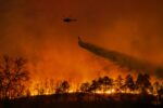 Fire fighting helicopter carry water bucket to extinguish the forest fire.